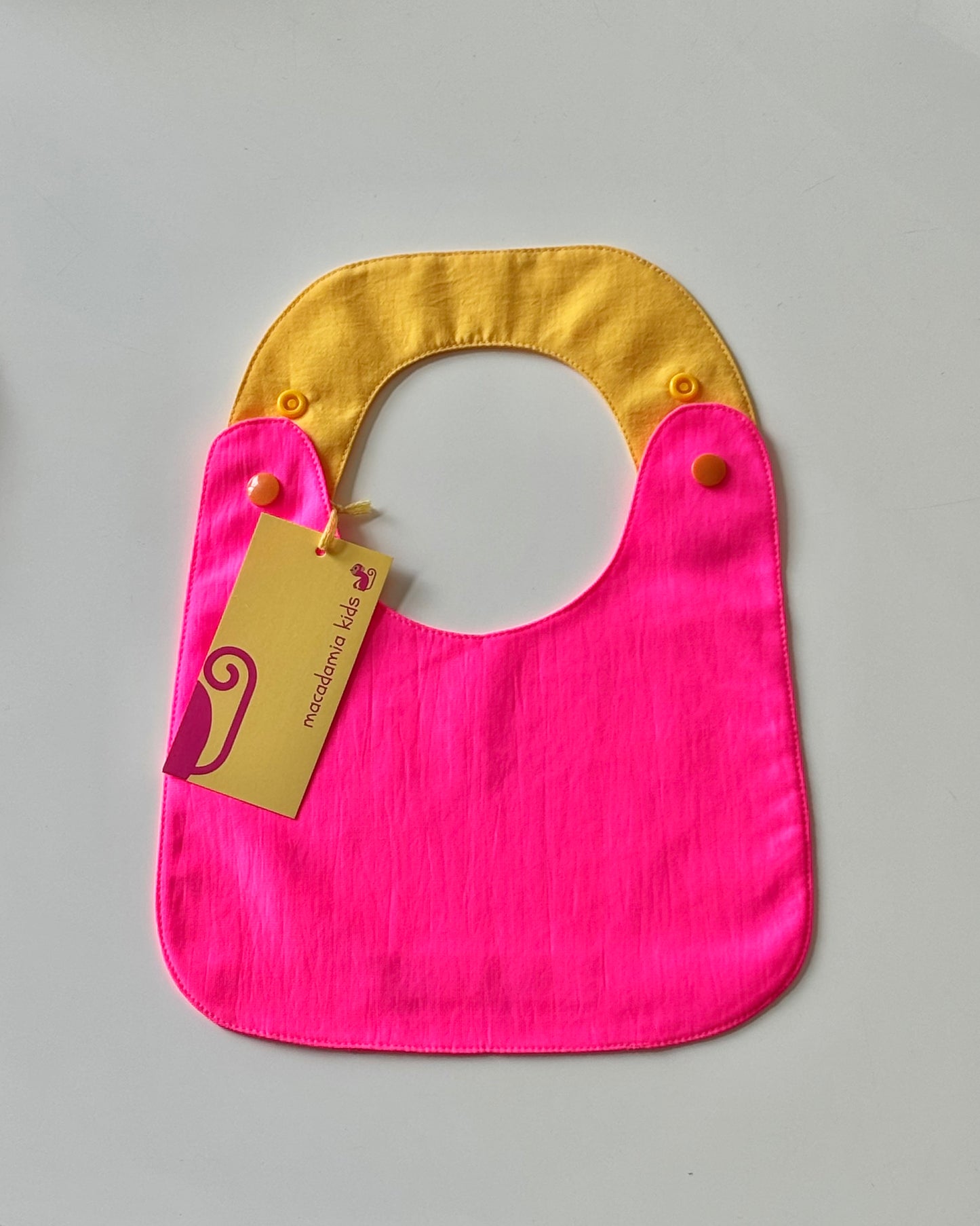 Babero reversible fucsia y amarillo