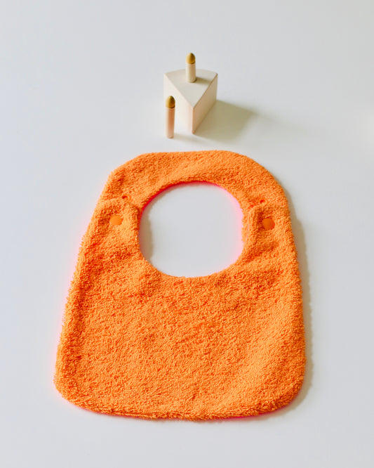 Babero reversible naranja/fucsia rizo de algodón