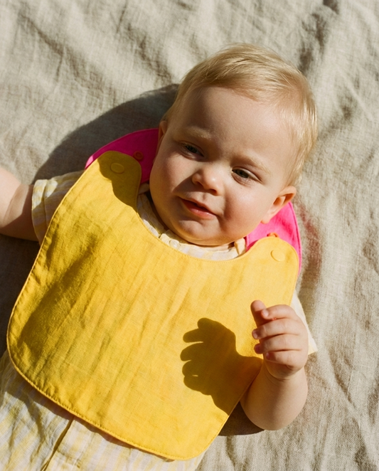 Babero reversible amarillo/fucsia