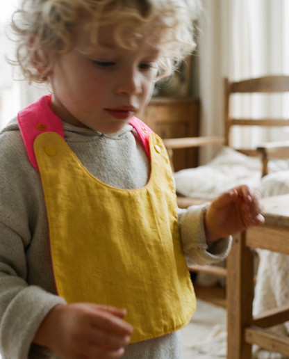 Babero reversible amarillo/fucsia