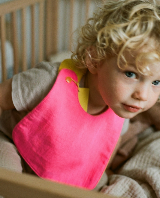 Babero reversible fucsia y amarillo