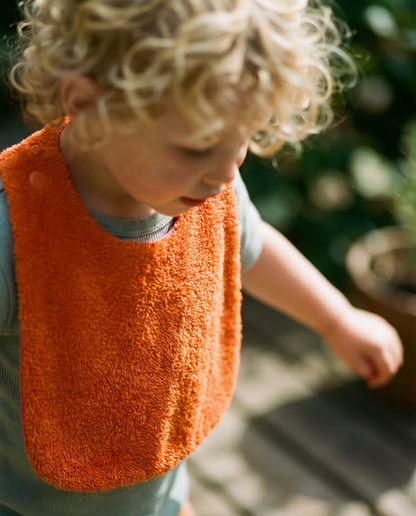 Reversible orange/fuchsia cotton terry bib