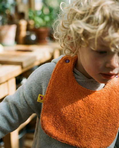 Babero reversible rizo naranja/muselina malva