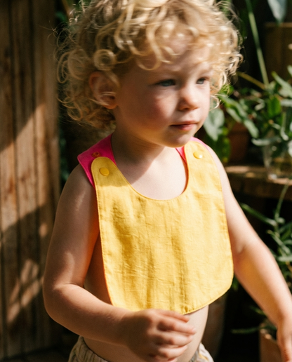 Babero reversible amarillo/fucsia