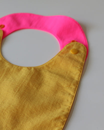 Babero reversible amarillo/fucsia