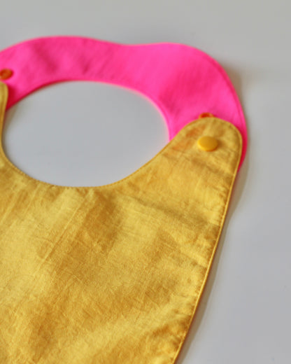 Babero reversible amarillo/fucsia