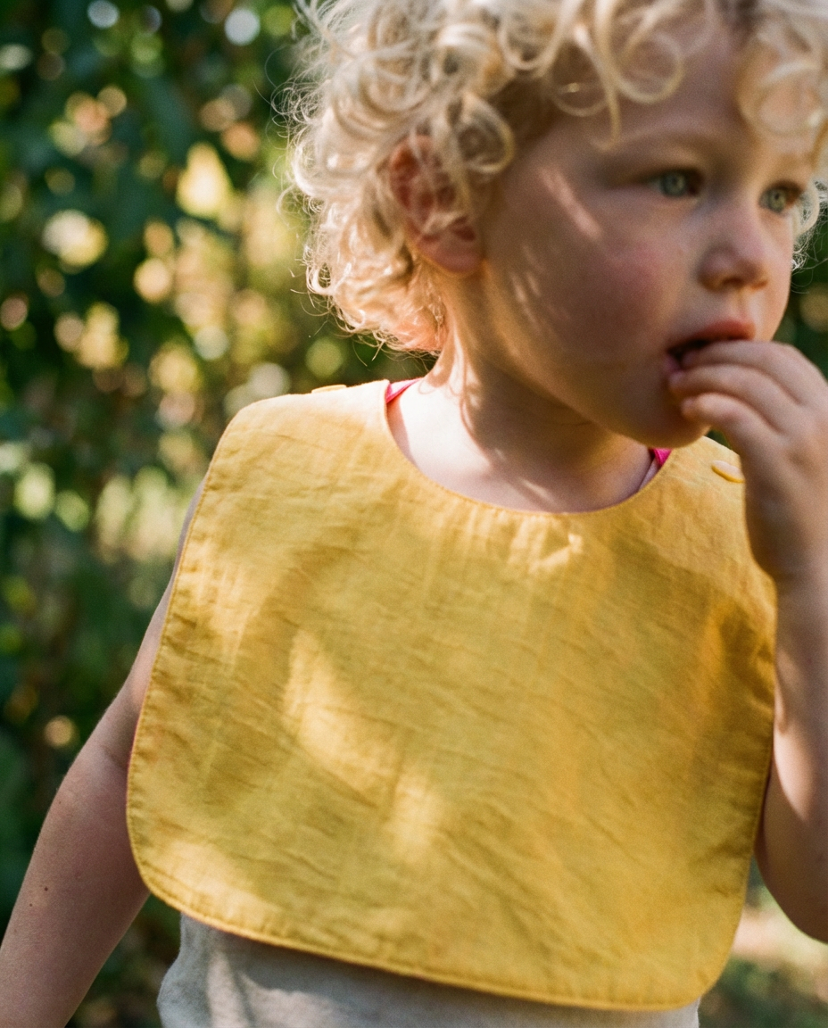 Babero reversible amarillo/fucsia