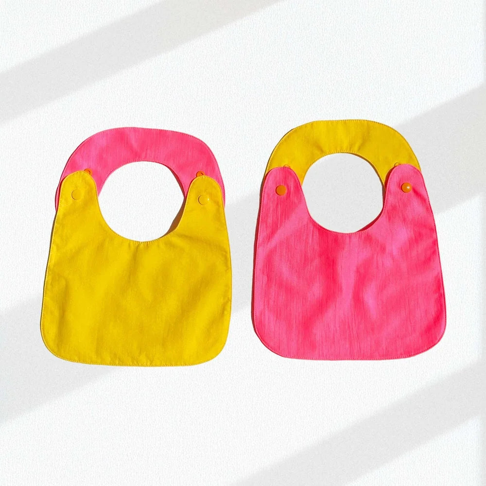 Pack de 2 baberos reversibles amarillo/fucsia