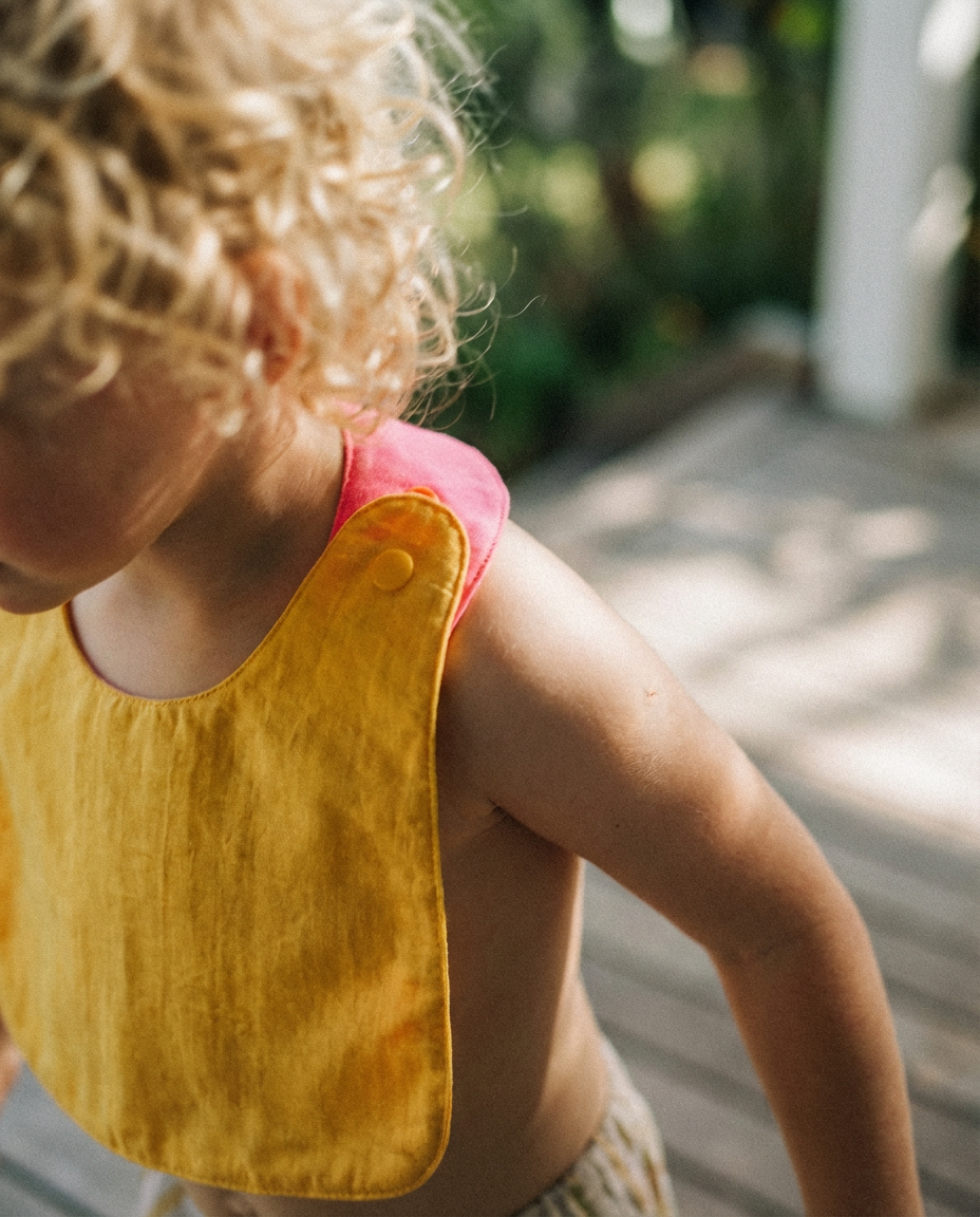 Babero reversible amarillo/fucsia